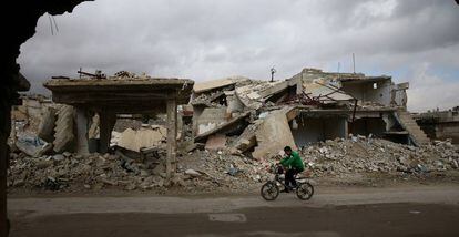 Un niño recorre en bicicleta las ruinas de la ciudad de Douma en Siria. 