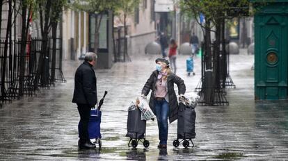 Una mujer protegida con mascarilla y guantes sanitarios realiza compras durante el sexto día del estado de alarma por coronavirus, en Madrid.
 
 