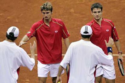 Juan Carlos Ferrero y Tommy Robredo, deportivos, felicitan con cara de circunstancias a sus vencedores.
