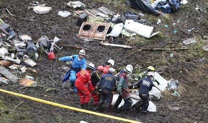 Varias personas trasladan un cadáver de uno de los pasajeros fallecidos en el accidente aéreo cerca de Medellín (Colombia).
