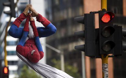 El colombiano Jahn Fredy Duque, vestido como Spiderman, actúa en las calles de Bogotá (Colombia). Duque utiliza en forma de telaraña una tela blanca de 26 metros de largo de la que se cuelga en un puente para conseguir así su sustento.