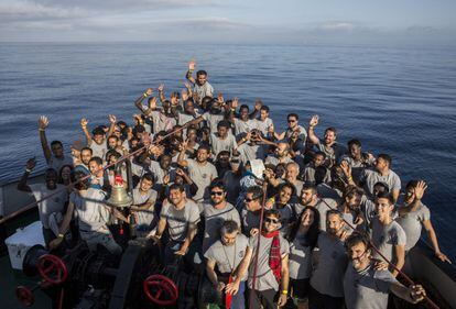 Migrantes y miembros de la tripulación a bordo del barco de ayuda Open Arms posan para una foto mientras el barco se acerca al puerto de Barcelona, el 4 de julio de 2018.