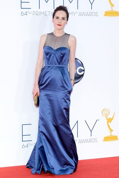 Michelle Dockery lleva un vestido azul de Louis Vuitton, joyas de Fred Leighton y una carterita de Jimmy Choo.