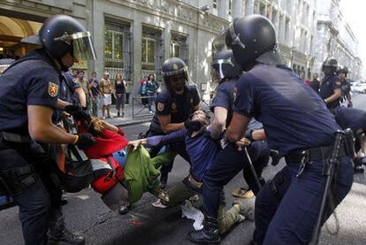 Varios policías arrastran a dos jóvenes durante el desalojo del paseo del Prado de Madrid.