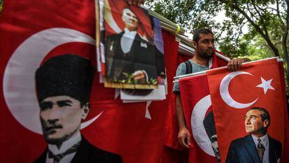 Unos vendedores de banderas sostienen retratos de Mustafa Kemal Ataturk, en Ankara (Turquía).