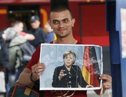 Un refugiado muestra una foto de la canciller alemana, Angela Merkel, al llegar a Múnich, en septiembre de 2015.