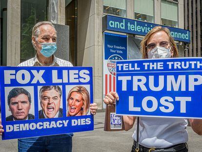 Dos manifestantes protestan ante el edificio de News Corp, el grupo del canal Fox News.