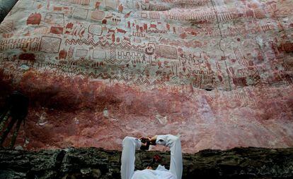Una mujer toma fotografías de las pinturas rupestres encontradas en Cerro Azul, en el departamento de Guaviare (Colombia).