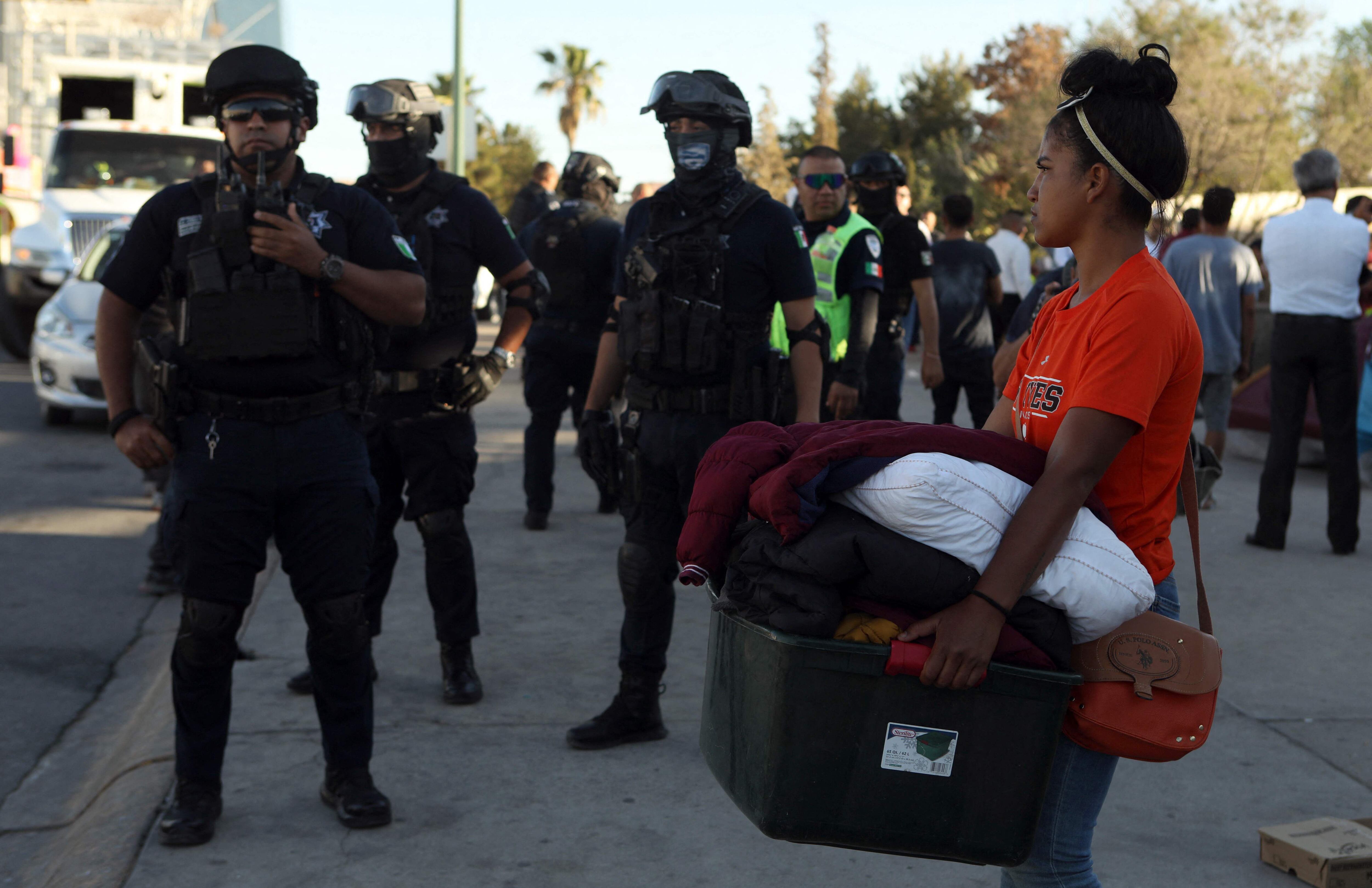Una migrante desalojada del campamento en Ciudad Juárez carga sus pertencias. 