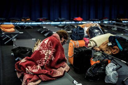 Una mujer descansa en un gimnasio donde se alojan las personas sin techo y sus familias, en Lyon, Francia. Han empezado a aplicarse las medidas del Plan Grand Froid del Gobierno francés en la región debido a la fuerte ola de frío que sufre Europa.