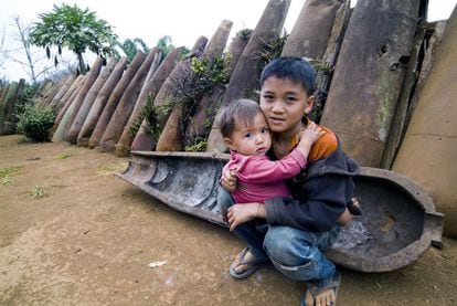 Dos niños juegan frente a un muro de carcasas de bombas de gran tamaño en un pequeño poblado de la provincia laosiana de Xieng Khuang. Muchos viven de la agricultura y consiguen un ingreso extra gracias a la venta de metal procedente de los proyectiles.