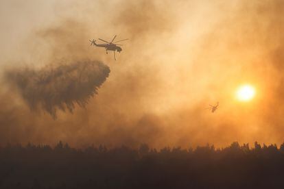 Un helicóptero vierte agua sobre el incendio en la zona de Varimpompi, al norte de Atenas.