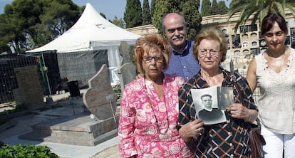 Josefa Celda (con fotos de su padre) entre dos familiares y con Matías Alonso, ayer en el cementerio de Paterna.