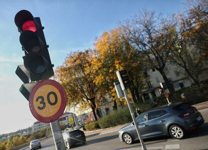Varios coches circulan al lado de una señal de tráfico en una vía de la capital el mismo día en que se aprobó la reducción de la velocidad hasta 20 kilómetros por hora en las ciudades y la pérdida de seis puntos por usar el móvil, en Madrid, el pasado 10 de noviembre.