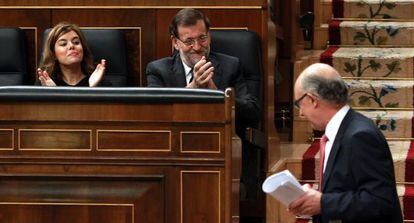 Rajoy y Santamaría aplauden a Montoro tras su discurso.