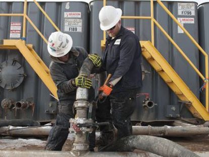 Dos operarios trabajan en una explotaci&oacute;n petrolera de Dakota del Norte.