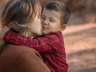 Una madre abraza a su hijo.