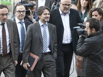 Josep Rull (izq.), actual presidente del Consell Nacional de Junts, y Jordi Turull, actual secretario general del partido independentista, arropan a Oriol Pujol Ferrusola a su llegada al Tribunal Superior de Justicia de Cataluña en 2013.