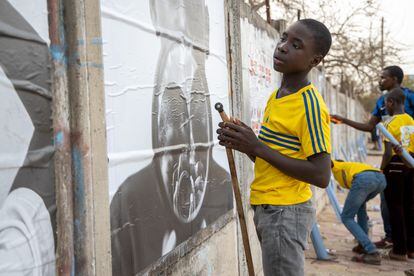 Un chico observa una de las fotos de la exposición 'Je suis là' en Dakar, Senegal, el día de su inauguración.