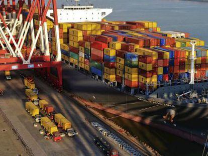 Camiones trasladan contenedores de un barco en el puerto de Qingdao (China)