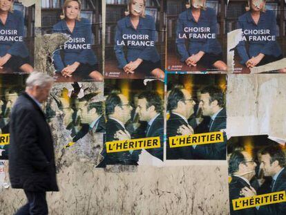 Un home passeja davant dels cartells electorals a París aquest divendres.