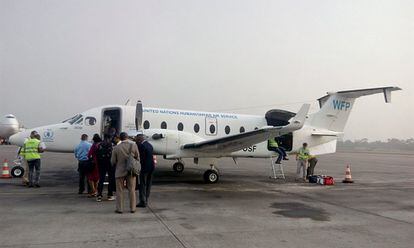 Empiezan pronto. Personal humanitario embarcando en un avión para ir a trabajar en Camerún a primera hora de la mañana.