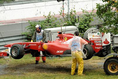 Los operarios retiran de la pista el coche de Fernando Alonso tras su accidente en el Gran Premio de Canadá.