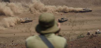 Un soldado israel&iacute; observa la evoluci&oacute;n de unos carros de combate durante unas maniobras militares de Israel cerca de Ein Zivan, en los Altos del Gol&aacute;n. 