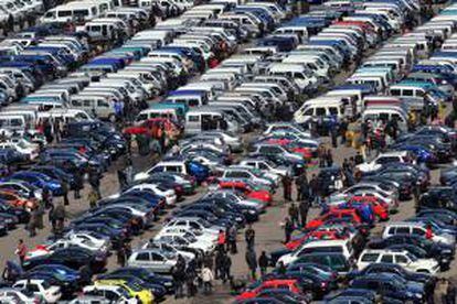 Decenas de personas miran coches en un concesionario. EFE/Archivo