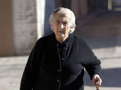 Una anciana pasea por la calle.