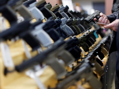 Clientes compran pistolas en la feria de armas de Des Moines (Iowa).