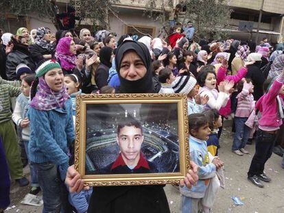 Una manifestante contra El Asad en Baba Amro muestra la foto de un desaparecido, el domingo.