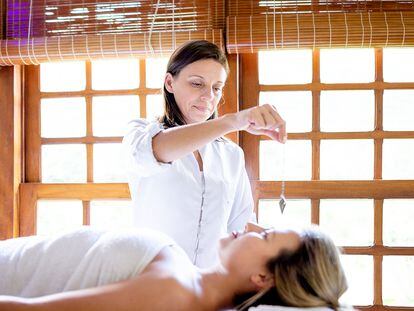 Mujer practica Reiki en una paciente.