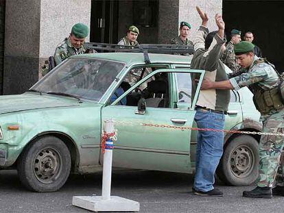 Un soldado libanés cachea a un hombre en un puesto de control ayer en Beirut.