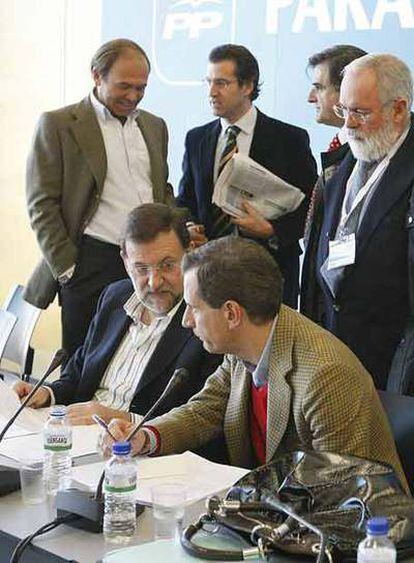 Mariano Rajoy y Juan Costa charlan sentados ante Pío García Escudero, Alberto Núñez Feijóo, Gabino de Lorenzo y Miguel Arias Cañete.