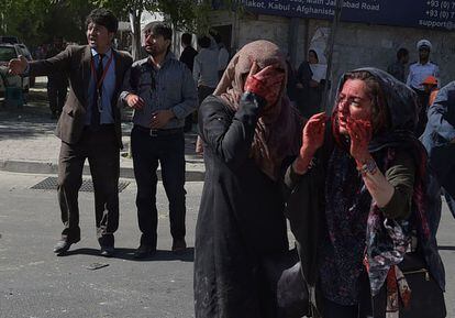 Dos mujeres heridas se lamentan tras el atentado con coche bomba de este miércoles en el centro de Kabul, la capital de Afganistán. La explosión ha causado al menos 80 muertos y 350 heridos a primera hora de esta mañana.