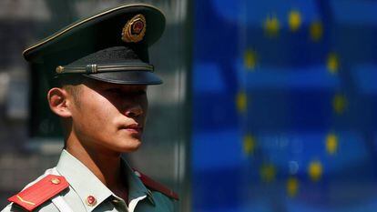 Un guarda chino frente a una bandera de la UE.