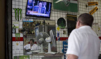 Un hombre mira la sesi&oacute;n del senado que decidir&aacute; la destituci&oacute;n de Rousseff.