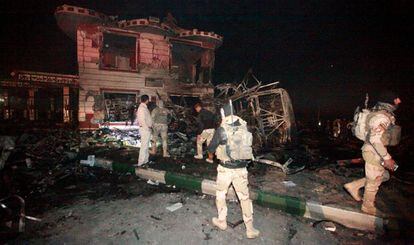Fuerzas de seguridad iraqu&iacute;es en la gasolinera calcinada por el atentado, este jueves en Al Hala (Irak).