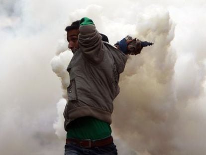 Un manifestante lanza un bote de gas lacrimógeno en El Cairo.