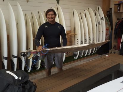 Mikala Jones sosteniendo una tabla de surf en California.