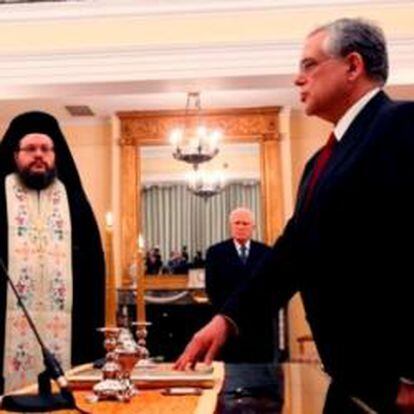 Lukas Papademos presta juramento ante sacerdotes ortodoxos en el palacio presidencial de Atenas