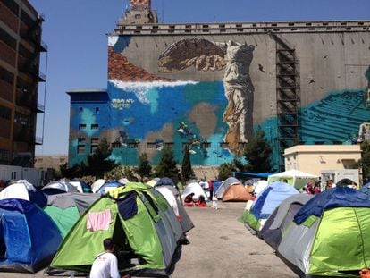 El campamento de refugiados del Pireo con un grafiti de la Victoria de Samotracia al fondo. 