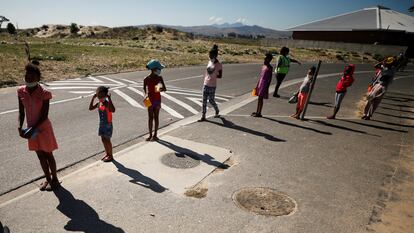 Niños hacen cola para recibir comida en un plan de alimentación escolar durante un cierre nacional destinado a frenar la propagación de la covid-19 en Blue Downs, cerca de Ciudad del Cabo, Sudáfrica, 4 de mayo de 2020.
