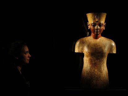 Una mujer observa un busto de madera de Tutankamón en The O2, de Londres.