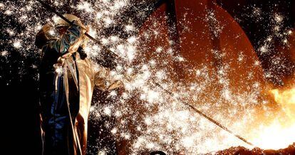 Un trabajador de la industria del acero del conglomerado alemán ThyssenKrupp permanece de pie junto a un alto horno.