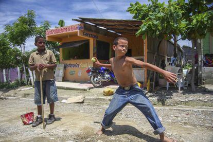 Unos niños juegan al beisbol en una de las calles del poblado.
