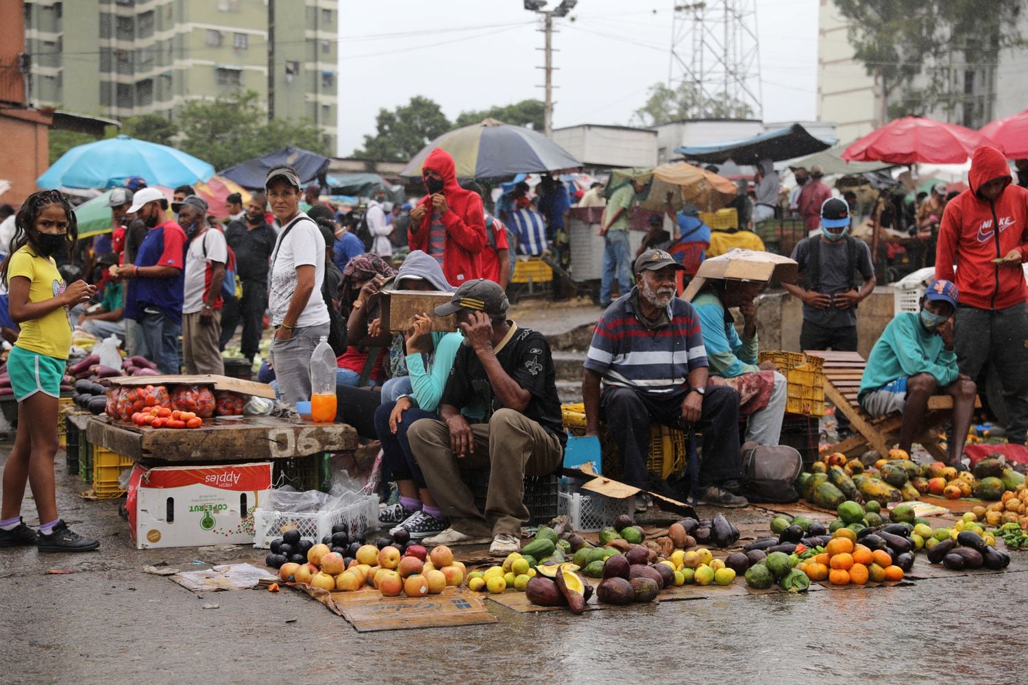 Vendedores trabajan bajo la lluvia en el mercado de Coche de Caracas.