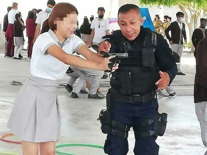 Un policía enseña a una alumna de la Secundaria Técnica 54, en Guanajuato, a manejar un arma de fuego.