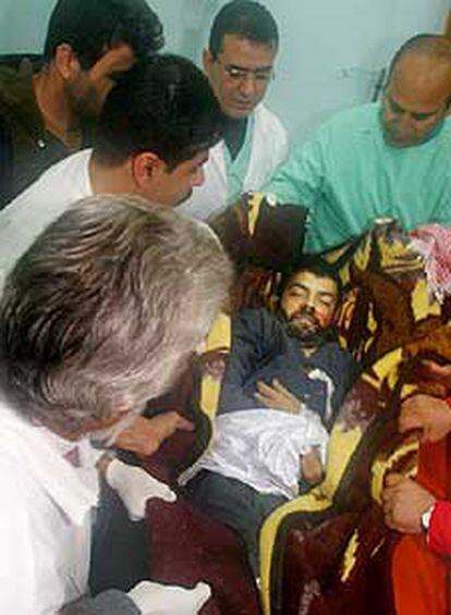 Médicos palestinos transportan en una manta el cuerpo sin vida del jefe de la Yihad Yasir Abuleish.